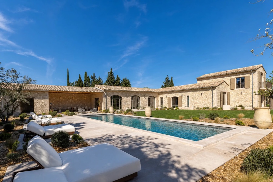 Provençal stone villa with a long pool and cypress trees